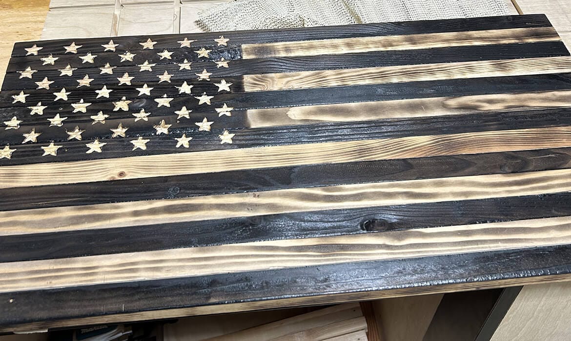 Wooden American flag with hand-carved stars and fire-charred finish